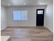 Bright living room with natural light, wood flooring, and modern black door at 1455 S Tennyson St, Denver, CO 80219