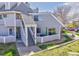 Exterior view of the apartment building with gray siding, staircase and a lush lawn at 8701 Huron # 207, Thornton, CO 80260