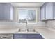 Stainless steel kitchen sink with tiled backsplash and window view at 2268 S Laredo St, Aurora, CO 80013