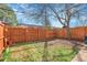 Fenced backyard with a combination of grass and dirt; has a beautiful tree in the corner for shade at 8312 S Saulsbury St # C, Littleton, CO 80128