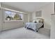 Cozy bedroom with a large window, plush carpeting, and a comfortable bed at 8312 S Saulsbury St # C, Littleton, CO 80128