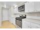 Well-lit kitchen featuring stainless steel appliances, white cabinets, and a gas range at 8312 S Saulsbury St # C, Littleton, CO 80128