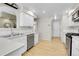 Bright kitchen featuring white cabinets, stainless steel appliances, and wood flooring at 8312 S Saulsbury St # C, Littleton, CO 80128