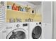 Convenient laundry area with washer, dryer, and shelving for optimal organization at 8312 S Saulsbury St # C, Littleton, CO 80128