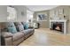 Bright living room with fireplace, light hardwood floors, and comfortable seating, ideal for relaxing or entertaining at 8312 S Saulsbury St # C, Littleton, CO 80128