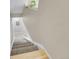 Carpeted staircase with white railings and natural light from a window above at 8312 S Saulsbury St # C, Littleton, CO 80128