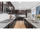 Modern kitchen featuring dark wood cabinets, stainless steel appliances, and granite countertops at 3014 Furthermore Ln, Castle Rock, CO 80108