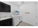 Well-lit laundry room with modern washer/dryer, sink, and dark cabinetry for ample storage at 3014 Furthermore Ln, Castle Rock, CO 80108