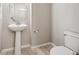 Simple and clean powder room featuring a pedestal sink and modern fixtures at 9269 Garnett St # C, Arvada, CO 80007