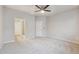 Spacious bedroom featuring plush carpet, neutral walls, a ceiling fan and an ensuite bathroom entrance at 9269 Garnett St # C, Arvada, CO 80007