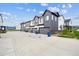 Row of modern townhomes featuring two-car garages and gray and white siding against a bright blue sky at 9269 Garnett St # C, Arvada, CO 80007