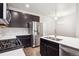 Contemporary kitchen featuring stainless steel appliances, dark wood cabinets, and quartz countertops at 9269 Garnett St # C, Arvada, CO 80007