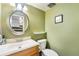 A well-lit bathroom featuring a stylish vanity, mirror, and fresh green paint at 628 S Carr St, Lakewood, CO 80226