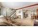 Inviting living room featuring neutral carpet, a plush sofa, and easy access to the dining area and staircase at 628 S Carr St, Lakewood, CO 80226