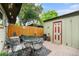 Inviting outdoor patio featuring a table, chairs, and access to the backyard shed at 628 S Carr St, Lakewood, CO 80226