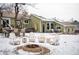 Inviting backyard with fire pit, outdoor seating, and patio area covered in snow at 1205 Lee St, Lakewood, CO 80215