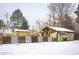 Fenced backyard with green house, covered patio and metal fence at 1205 Lee St, Lakewood, CO 80215