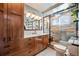 Modern bathroom features wood cabinets, quartz countertops, tiled shower with glass door and natural light at 1205 Lee St, Lakewood, CO 80215