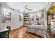 Charming bedroom featuring hardwood floors, a ceiling fan, and abundant natural light from multiple windows at 1205 Lee St, Lakewood, CO 80215