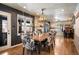 Dining room with a stone fireplace, a wooden table with patterned chairs, and a modern chandelier at 1205 Lee St, Lakewood, CO 80215