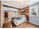 Comfortable main bedroom with hardwood floors, a wood accent wall, a large window, and plenty of storage space at 1205 Lee St, Lakewood, CO 80215