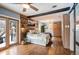 Sunlit main bedroom featuring a wood accent wall, hardwood floors, and access to a private balcony at 1205 Lee St, Lakewood, CO 80215