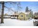 Charming single-story home with a brick chimney, adjacent carport, and a spacious snow-covered yard at 1205 Lee St, Lakewood, CO 80215