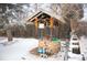 Outdoor well feature with stone base, wooden structure, and winter landscape at 1205 Lee St, Lakewood, CO 80215