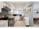 Bright kitchen featuring stainless steel appliances, white cabinets, light countertops, and stylish blue backsplash at 13952 E Marina Dr # 310, Aurora, CO 80014