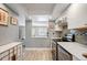 Modern kitchen with stainless steel appliances, white cabinets, light countertops, and view to the living room at 13952 E Marina Dr # 310, Aurora, CO 80014