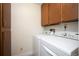 Functional laundry room with side-by-side washer and dryer and overhead storage cabinets at 13952 E Marina Dr # 310, Aurora, CO 80014