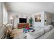 Bright living room featuring a comfortable couch, entertainment center, and access to kitchen at 13952 E Marina Dr # 310, Aurora, CO 80014