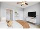 Bright bedroom featuring ceiling fan, television, white dresser and views from the door and closet at 2662 S Cathay Way # 302, Aurora, CO 80013