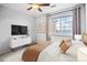 Bright bedroom featuring ceiling fan, television, white dresser and views from the window at 2662 S Cathay Way # 302, Aurora, CO 80013