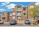 Exterior shot of a multi-story brick apartment building with private balconies and well-maintained landscaping at 2662 S Cathay Way # 302, Aurora, CO 80013