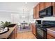 Kitchen featuring wood cabinets, black appliances, tile flooring, and an adjacent dining area with carpet at 2662 S Cathay Way # 302, Aurora, CO 80013