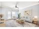 Bright living room with white contemporary furniture, ceiling fan, large window and balcony door at 2662 S Cathay Way # 302, Aurora, CO 80013