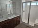 Bright bathroom featuring double vanity, modern fixtures, and a sleek, glass-enclosed shower at 6077 Idlewild Pl, Brighton, CO 80601