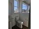 Clean powder room with a pedestal sink, toilet, and a window providing natural light at 6077 Idlewild Pl, Brighton, CO 80601