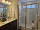 Bathroom featuring double vanity, tiled shower, and neutral color palette at 6077 Idlewild Pl, Brighton, CO 80601