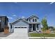 Charming two-story home with a two-car garage, covered porch, and manicured lawn at 6077 Idlewild Pl, Brighton, CO 80601