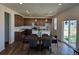 Open-concept kitchen with a center island, modern appliances, and dark wood cabinetry at 6077 Idlewild Pl, Brighton, CO 80601