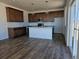 Spacious kitchen boasts wood floors, modern island, and stainless steel appliances at 6077 Idlewild Pl, Brighton, CO 80601