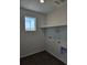 Functional laundry room equipped with a convenient shelf and essential hookups at 6077 Idlewild Pl, Brighton, CO 80601