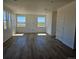 Bright living room with hardwood floors, many windows, and an open floor plan at 6077 Idlewild Pl, Brighton, CO 80601