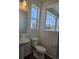 Modern powder room with a pedestal sink, sleek fixtures, and neighborhood views at 6077 Idlewild Pl, Brighton, CO 80601
