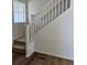 Carpeted staircase with white railing and wood flooring, providing access to upper levels at 6077 Idlewild Pl, Brighton, CO 80601