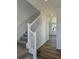 Carpeted staircase with white banister leads to the upper level of the home at 6077 Idlewild Pl, Brighton, CO 80601