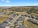 Aerial view of a neighborhood situated in a desert landscape, complemented by a distant lake at 2230 Rim Ridge Dr, Castle Pines, CO 80108