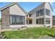 Backyard featuring a concrete patio, healthy green grass and a modern exterior elevation at 2230 Rim Ridge Dr, Castle Pines, CO 80108